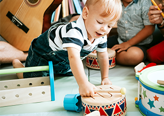 child reaching for a drum